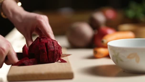 Mani delle donne affettare la barbabietola sul tagliere di legno — Video Stock