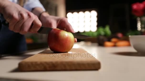 Mujer con cuchillo cortando manzana en tabla de cortar — Vídeos de Stock