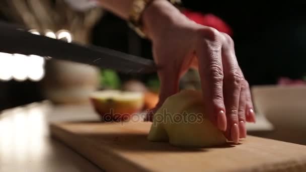 Vrouwelijke hand geschilde appel snijden op snijplank — Stockvideo