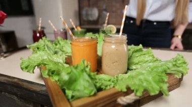 Kadın hizmet tepsi renkli smoothies ile