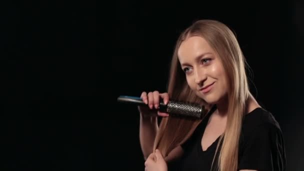 Привлекательная женщина расчесывает длинные прямые светлые волосы — стоковое видео