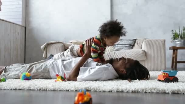 カーペットの上に横たわる幼児の息子との接着の父 — ストック動画