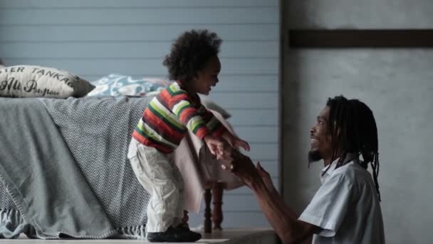 Игривый папа-хипстер играет со своим сыном дома — стоковое видео