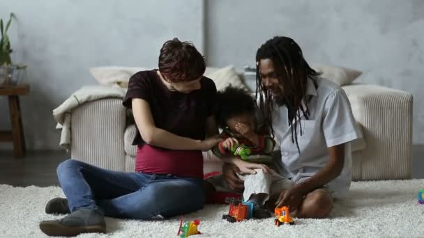 Famille joyeuse et diversifiée avec son fils relaxant à la maison — Video