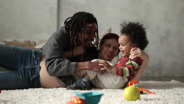 Famille interraciale avec enfant jouant sur le sol — Video