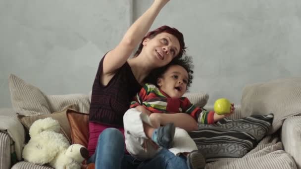 Madre jugando con el niño de raza mixta hijo en el sofá — Vídeos de Stock