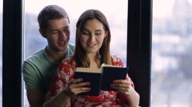 Tatlı genç çift birlikte evde kitap okurken