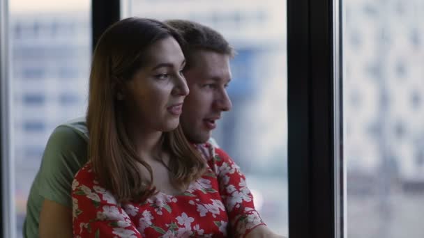 Fredliga ungt par tittar genom fönstret — Stockvideo