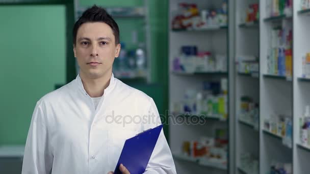 Farmacista maschio sorridente in camice bianco in farmacia — Video Stock