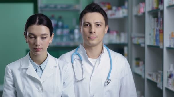 Farmacéuticos amigables sonrientes que trabajan en farmacia — Vídeo de stock