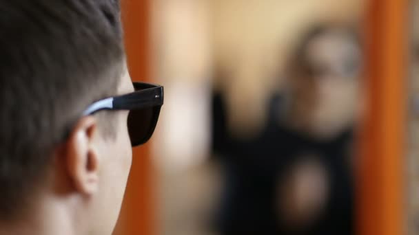 Stylowy mężczyzna szuka najlepsze okulary przeciwsłoneczne — Wideo stockowe
