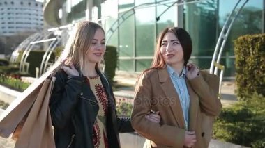 Alışveriş torbaları sokakta yürüyen mutlu kadınlarla