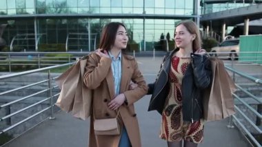 Genç şirin çok ırklı kızlar alışveriş torbaları ile