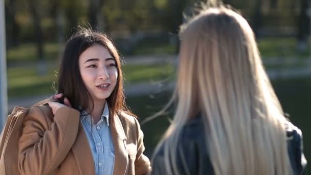 Glada asiatisk tjej skvallra med väninna — Stockvideo