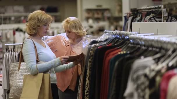 Duas mulheres comprando roupas no departamento de moda — Vídeo de Stock