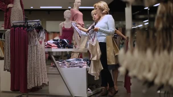Positiva kvinnliga vänner att välja kläder i butik — Stockvideo