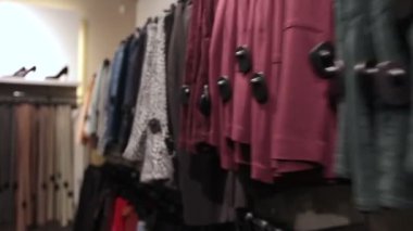 Giysiler moda mağazasında askıda asılı.