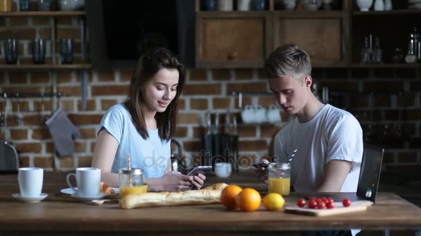 Pareja desayunando mientras usa teléfonos móviles — Vídeo de stock