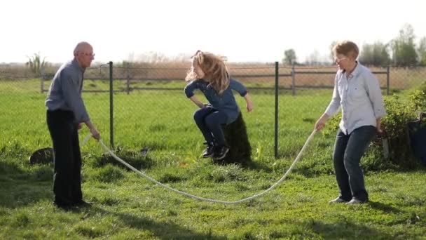 Hermosa niña saltando sobre la cuerda al aire libre — Vídeo de stock