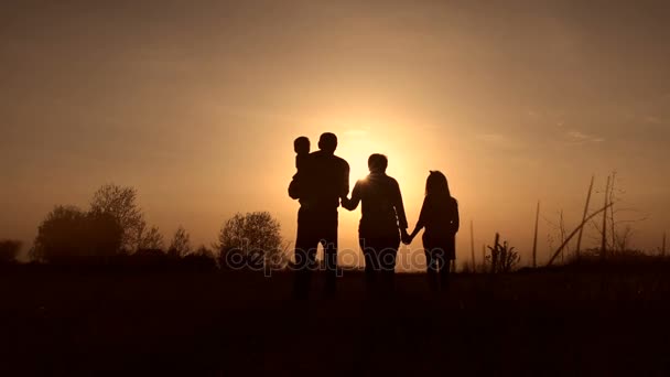Siluetter av mor-och farföräldrar med barn vid solnedgången — Stockvideo
