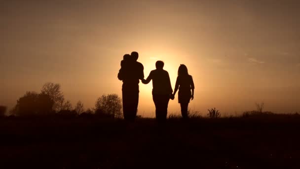 Siluetas familiares en espirng puesta de sol en el prado — Vídeos de Stock