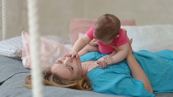 Mama vesela se joaca cu bebelusul ei in pat — Videoclip de stoc