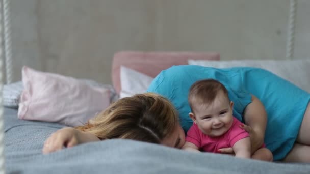 Affectionate young mother kissing her baby girl — Stock Video