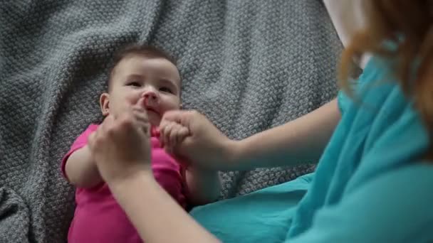 Мама массирует и делает гимнастику своему ребенку — стоковое видео