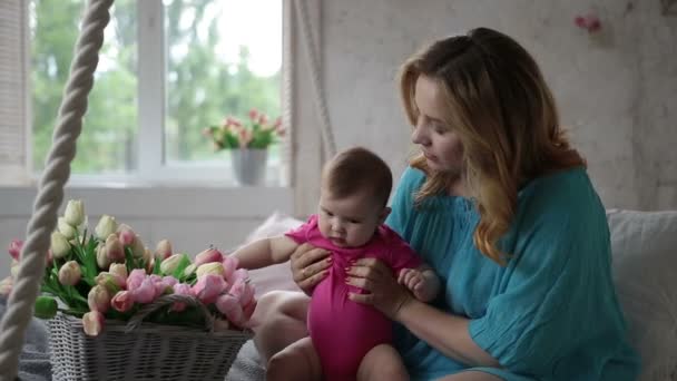 Schattig babymeisje speelt met tulp bloemen — Stockvideo