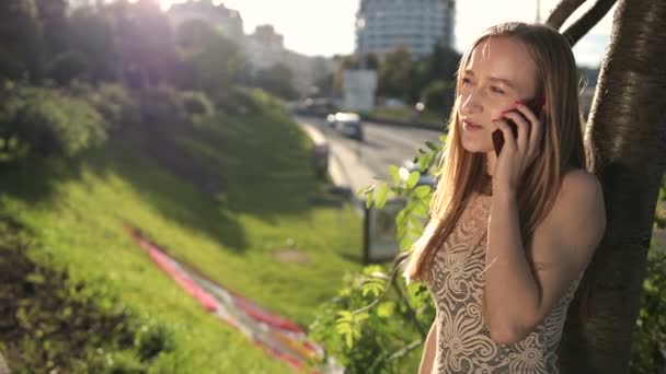 Veselá blond žena mluví o telefonu venku — Stock video