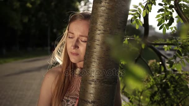 Zdesperowanych kobieta opierając głowę na pniu drzewa — Wideo stockowe