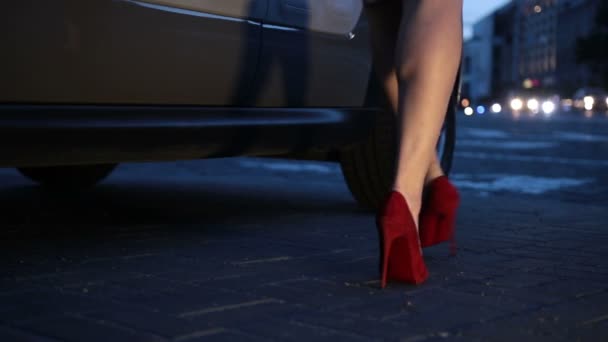 Sexy piernas en tacones entrar en el coche por la noche — Vídeos de Stock