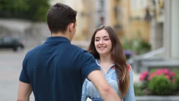 Ung man dölja blommor för flickan bakom hans rygg — Stockvideo