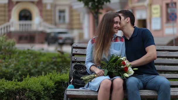 Atraente namoro casal sentado no banco no parque — Vídeo de Stock