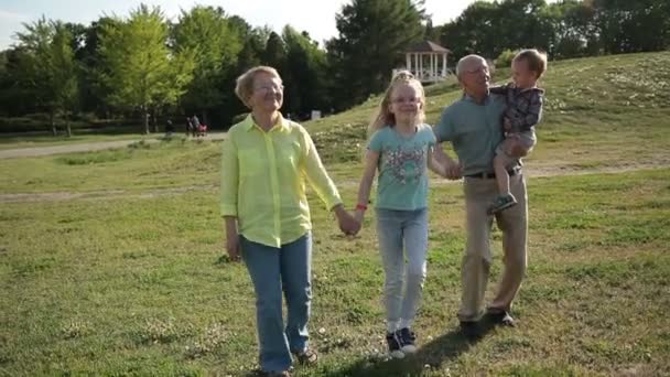 Glückliche Familie mit Kindern, die Spaß im Park haben — Stockvideo