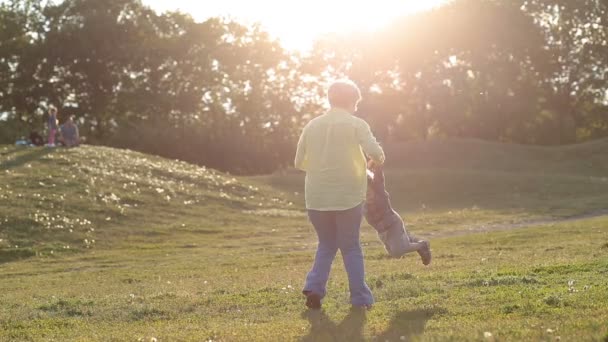 Feliz abuela girando nieto en círculo — Vídeos de Stock