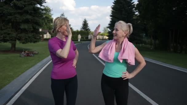 Жінки, що біжать, дають високі п'ять після тренування — стокове відео