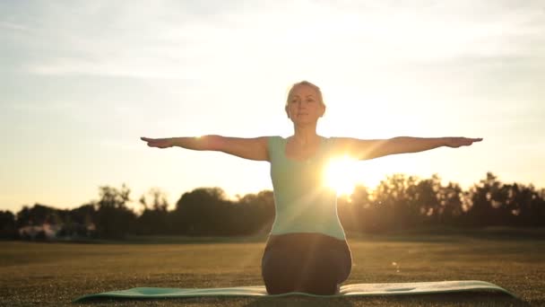 Žena fitness cvičení jógy představuje při západu slunce — Stock video