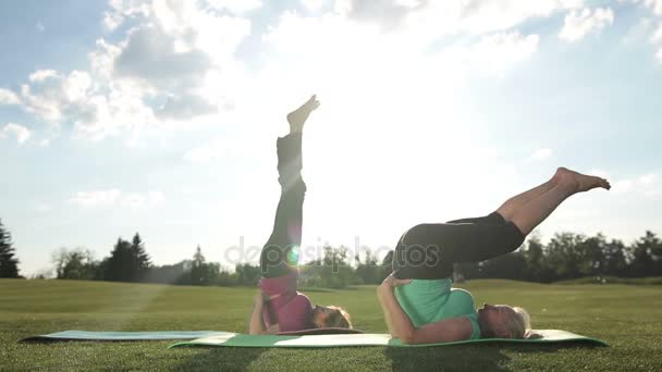 Sportieve dames doen ondersteboven zegel vormen buiten — Stockvideo