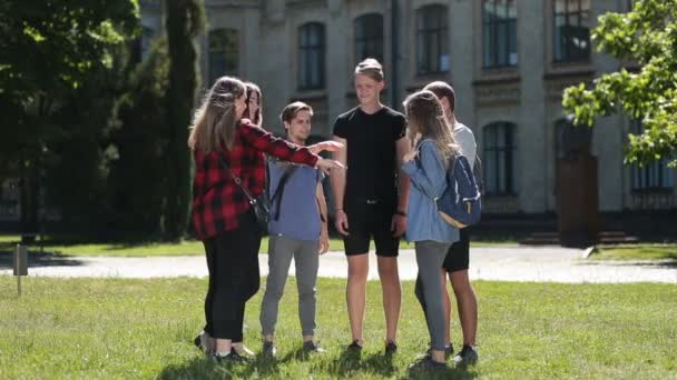 Estudiantes universitarios felices con las manos en la pila — Vídeo de stock