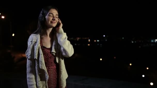 ヘッドフォンで音楽を楽しむ穏やかなブルネットの女性 — ストック動画