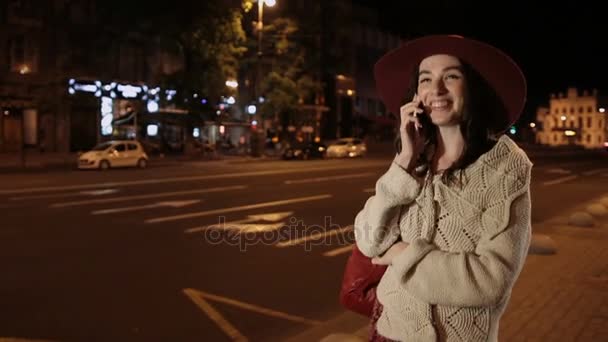 Щаслива дівчина розмовляє по мобільному телефону в нічному місті — стокове відео