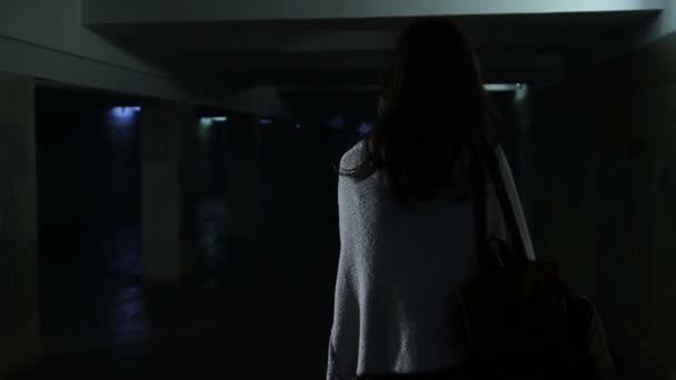 Angstige vrouw uitgevoerd door donkere voetgangerstunnel — Stockvideo