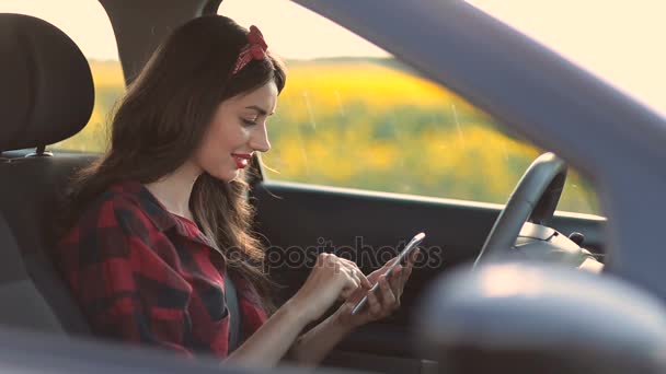 Mulher encantadora usando smartphone enquanto dirige o carro — Vídeo de Stock