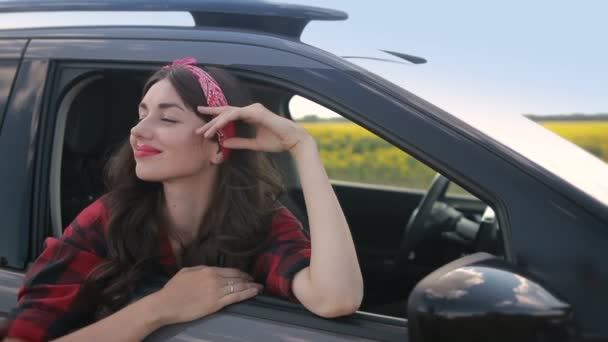 Портрет счастливой женщины, прислонившейся к окну машины — стоковое видео