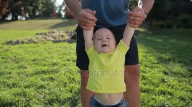 Ellerinizle Park toddler bebek oğlunu sallanan adam
