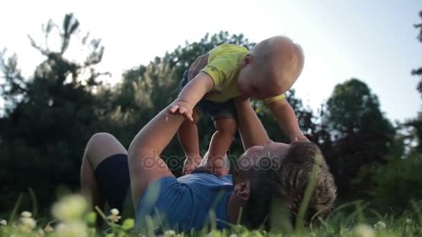 Unbekümmerter Vater hält niedlichen kleinen Sohn im Freien hoch — Stockvideo