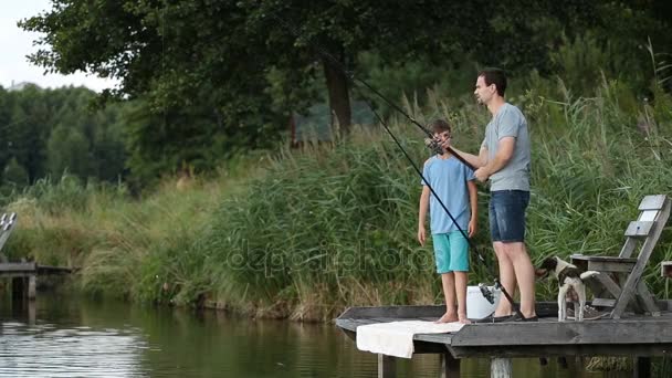 Отец-хипстер и мальчик наслаждаются рыбалкой у пруда — стоковое видео