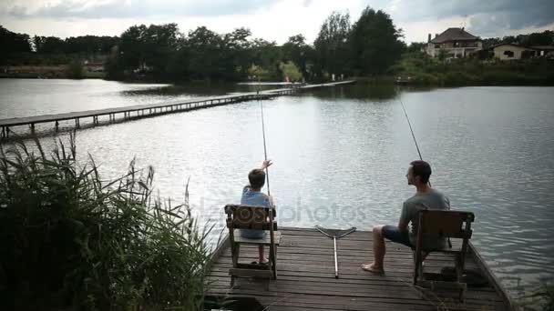 Отец и сын проводят досуг рыбалки в пруду — стоковое видео