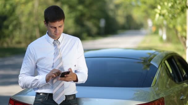 Jeune homme d'affaires naviguant net avec téléphone en plein air — Video